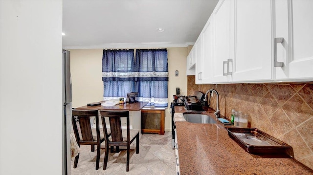 20 Overhill Pl, Yonkers, NY 10704 - kitchen with white cabinetry, ornamental molding, decorative backsplash, freestanding refrigerator, and light stone counters