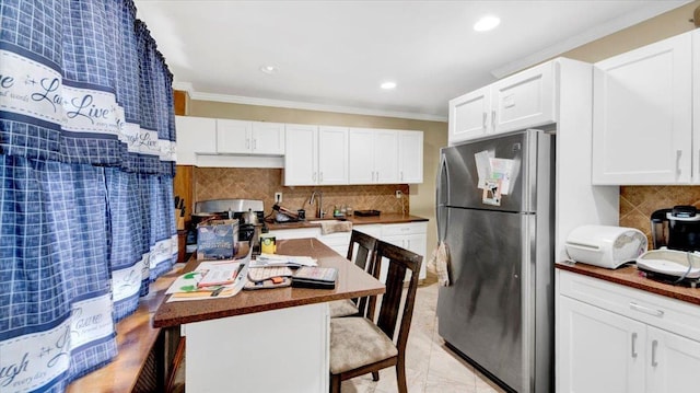20 Overhill Pl, Yonkers, NY 10704 - kitchen featuring freestanding refrigerator, a kitchen breakfast bar, decorative backsplash, white cabinetry, and ornamental molding