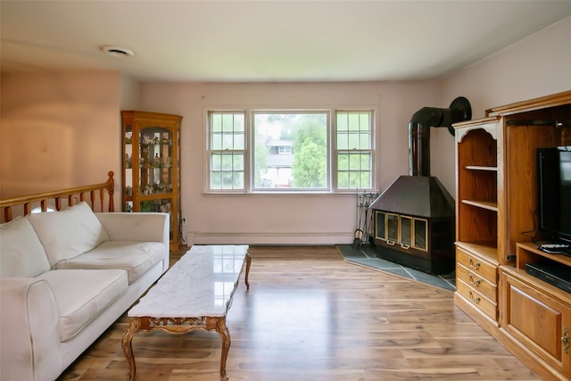 180 Hunter Ave, North Babylon, NY 11703 - living room featuring a wood stove, baseboard heating, and light wood-style flooring