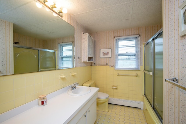 180 Hunter Ave, North Babylon, NY 11703 - full bath featuring wallpapered walls, baseboard heating, vanity, tile walls, and a wainscoted wall