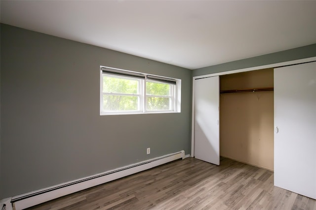 180 Hunter Ave, North Babylon, NY 11703 - unfurnished bedroom featuring baseboard heating, light wood-style floors, and a closet