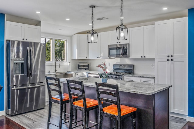 15 Aron Dr, Bohemia, NY 11716 - kitchen featuring stainless steel appliances, light stone counters, white cabinetry, a kitchen island, and recessed lighting