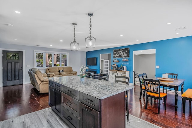 15 Aron Dr, Bohemia, NY 11716 - kitchen with wood finished floors, recessed lighting, a kitchen bar, pendant lighting, and light stone countertops