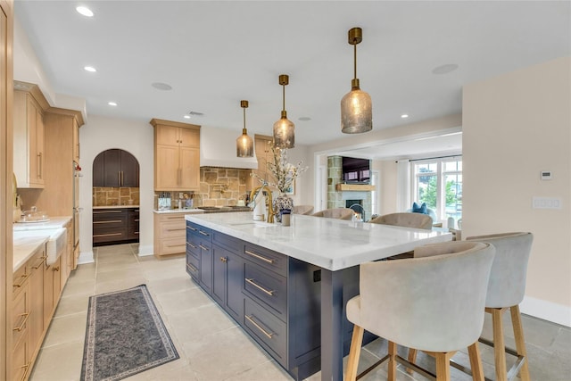 52 Concourse E, Brightwaters, NY 11718 - kitchen featuring light brown cabinetry, decorative backsplash, a fireplace, recessed lighting, and a large island