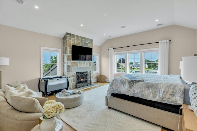 52 Concourse E, Brightwaters, NY 11718 - bedroom with lofted ceiling, multiple windows, a stone fireplace, recessed lighting, and wood finished floors