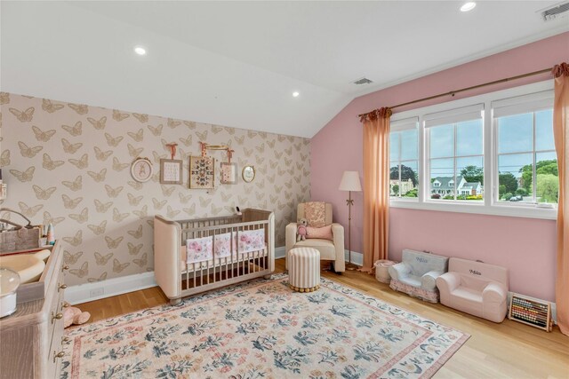 52 Concourse E, Brightwaters, NY 11718 - bedroom with wallpapered walls, wood finished floors, vaulted ceiling, a crib, and recessed lighting