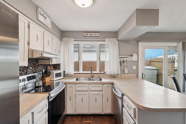 17 Lombardy Dr, Shirley, NY 11967 - kitchen featuring stainless steel appliances, under cabinet range hood, a peninsula, light countertops, and plenty of natural light