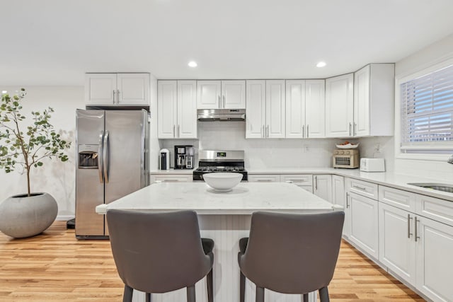 652 Arthur St, Baldwin Harbor, NY 11510 - kitchen with stainless steel appliances, under cabinet range hood, light wood-style floors, white cabinetry, and recessed lighting