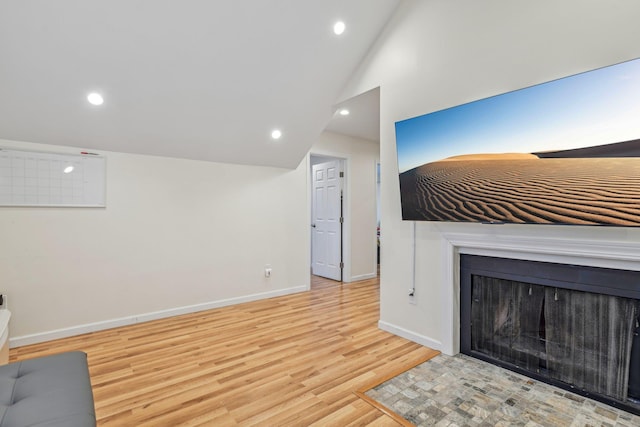 652 Arthur St, Baldwin Harbor, NY 11510 - unfurnished living room with wood finished floors, recessed lighting, vaulted ceiling, and a fireplace with flush hearth