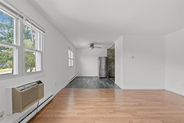 14 E White Gate Rd, Wappingers Falls, NY 12590 - unfurnished living room featuring baseboard heating, wood finished floors, ceiling fan, a baseboard heating unit, and a wall mounted AC