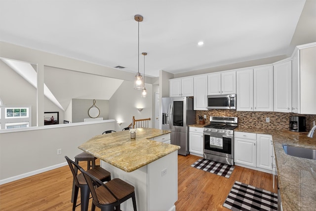 311 Myers Corners Rd, Wappingers Falls, NY 12590 - kitchen with appliances with stainless steel finishes, light wood finished floors, backsplash, lofted ceiling, and white cabinetry