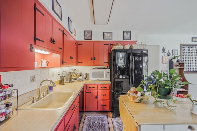 12 Pine Cone St, Middle Island, NY 11953 - kitchen with red cabinets, black appliances, backsplash, and light wood-style flooring