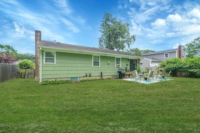 12 Pine Cone St, Middle Island, NY 11953 - rear view of house with a patio area, a fenced backyard, and a chimney