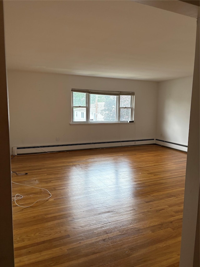 68 Loring Ave, Yonkers, NY 10704 - empty room with wood finished floors and a baseboard heating unit
