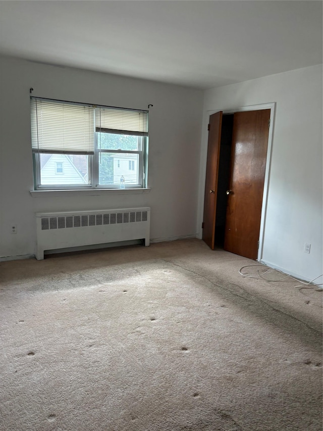 68 Loring Ave, Yonkers, NY 10704 - carpeted empty room featuring radiator and healthy amount of natural light