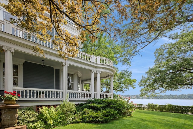 28 Shore Rd, Douglaston, NY 11363 - view of side of home with a water view, a porch, and a yard