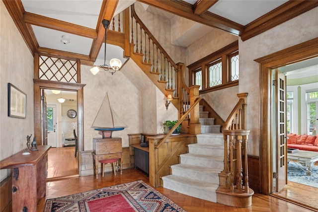 28 Shore Rd, Douglaston, NY 11363 - stairway with coffered ceiling, a chandelier, beamed ceiling, a towering ceiling, and ornamental molding