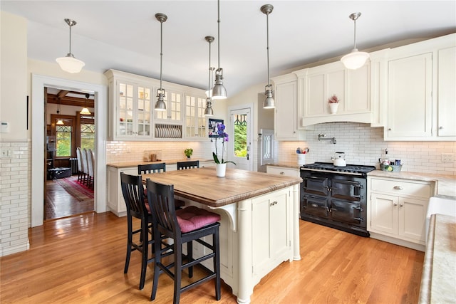 28 Shore Rd, Douglaston, NY 11363 - kitchen with double oven range, white cabinets, light wood-style floors, tasteful backsplash, and lofted ceiling