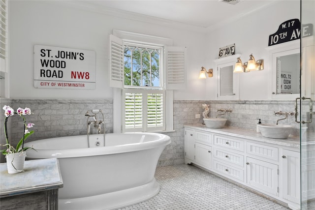 28 Shore Rd, Douglaston, NY 11363 - full bath featuring tile walls, healthy amount of natural light, double vanity, a freestanding bath, and a wainscoted wall