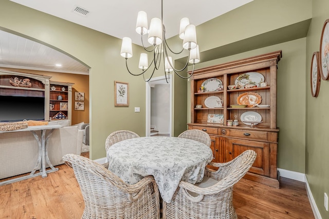 6 Memas Ct, Dix Hills, NY 11746 - dining area featuring arched walkways, a chandelier, and wood finished floors
