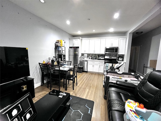 82-13 32nd Ave, East Elmhurst, NY 11370 - kitchen featuring appliances with stainless steel finishes, white cabinetry, light wood-type flooring, and recessed lighting
