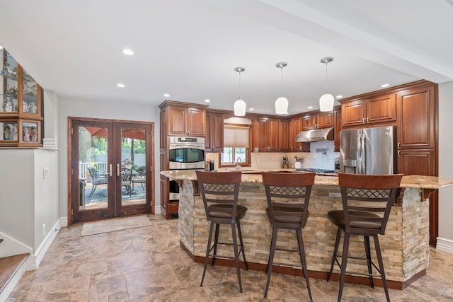 20 Tulipwood Dr, Commack, NY 11725 - kitchen featuring appliances with stainless steel finishes, under cabinet range hood, french doors, light stone finish flooring, and light stone counters