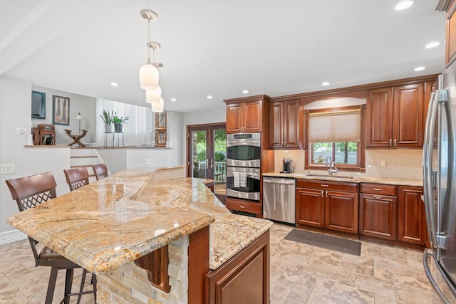 20 Tulipwood Dr, Commack, NY 11725 - kitchen with appliances with stainless steel finishes, decorative backsplash, a kitchen island, a breakfast bar area, and light stone counters