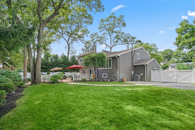 20 Tulipwood Dr, Commack, NY 11725 - back of house featuring a gate, a chimney, a wooden deck, and asphalt driveway