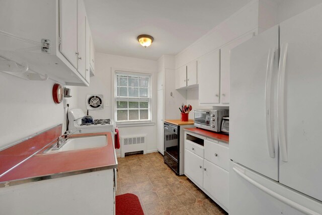 118 Robins Rd Unit 118, New Rochelle, NY 10801 - kitchen with freestanding refrigerator, white cabinetry, radiator heating unit, and dishwasher