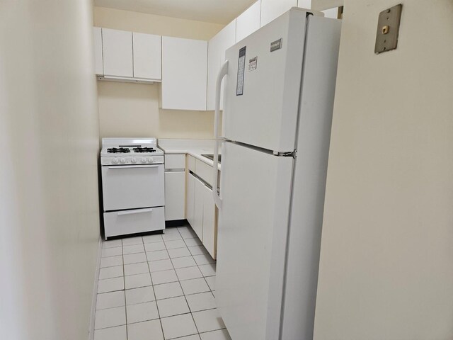 87-30 62nd Ave Unit 7F, Rego Park, NY 11374 - kitchen featuring white appliances, light tile patterned floors, white cabinetry, and light countertops