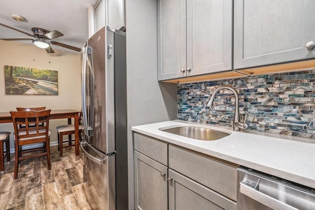 42 Richmond Blvd Unit 3B, Ronkonkoma, NY 11779 - kitchen with appliances with stainless steel finishes, a ceiling fan, wood finished floors, backsplash, and gray cabinetry