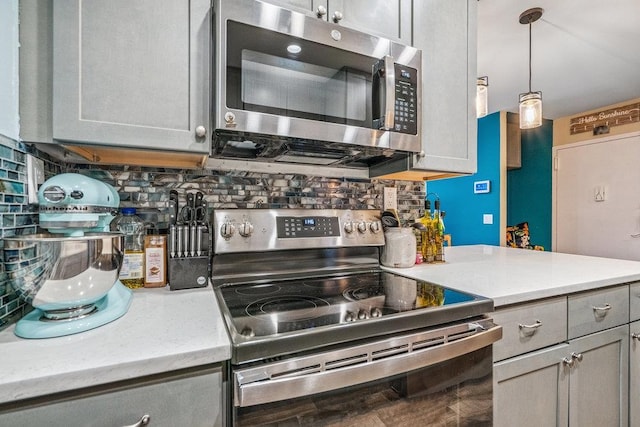 42 Richmond Blvd Unit 3B, Ronkonkoma, NY 11779 - kitchen featuring stainless steel appliances, tasteful backsplash, gray cabinetry, hanging light fixtures, and light stone counters