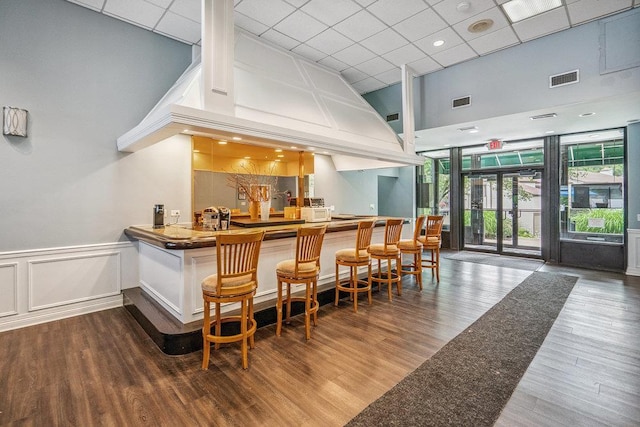 42 Richmond Blvd Unit 3B, Ronkonkoma, NY 11779 - indoor wet bar with a towering ceiling, wood finished floors, a paneled ceiling, a decorative wall, and a wainscoted wall