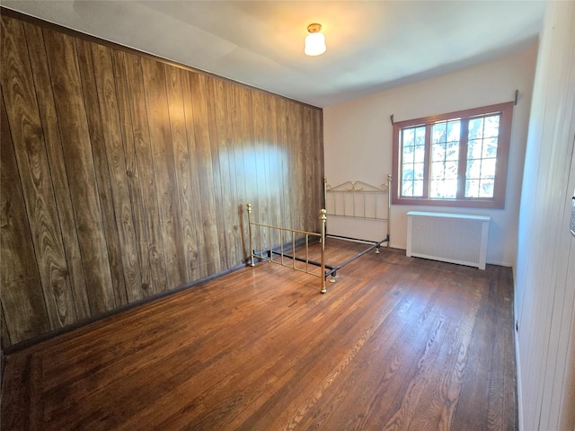 69-37 Central Ave, Glendale, NY 11385 - spare room featuring radiator heating unit and wood finished floors