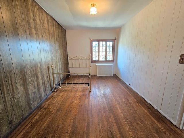 69-37 Central Ave, Glendale, NY 11385 - empty room featuring radiator, wood finished floors, and wood walls