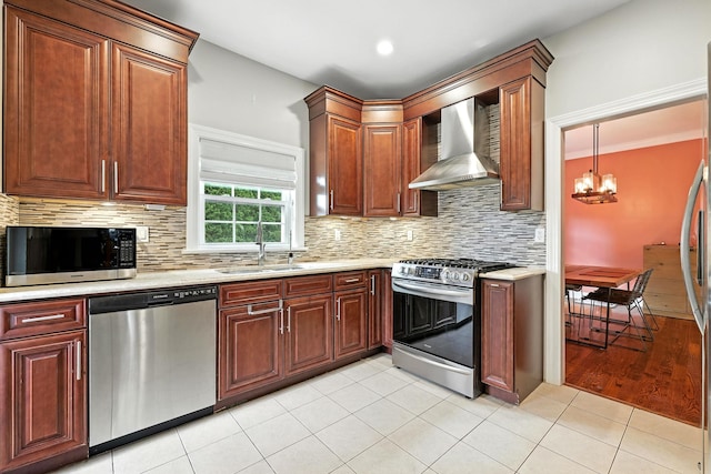 27 S Goodwin Ave, Elmsford, NY 10523 - kitchen featuring appliances with stainless steel finishes, wall chimney exhaust hood, a chandelier, tasteful backsplash, and light tile patterned flooring