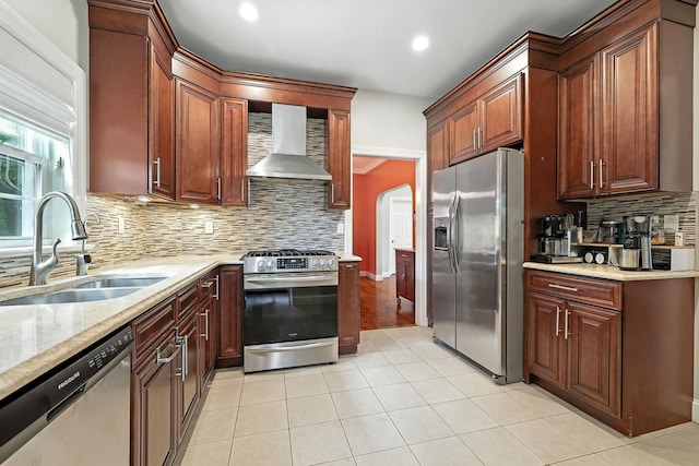 27 S Goodwin Ave, Elmsford, NY 10523 - kitchen with stainless steel appliances, wall chimney range hood, decorative backsplash, arched walkways, and light stone counters