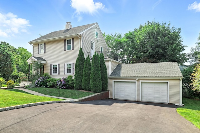 27 S Goodwin Ave, Elmsford, NY 10523 - view of front facade with a garage, a chimney, a front yard, asphalt driveway, and a shingled roof