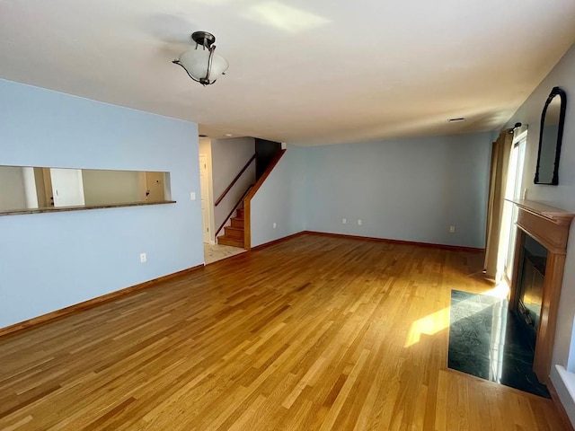 728 Woodland Estates Dr, Baldwin, NY 11510 - unfurnished living room with stairway, light wood-style flooring, and a fireplace with flush hearth