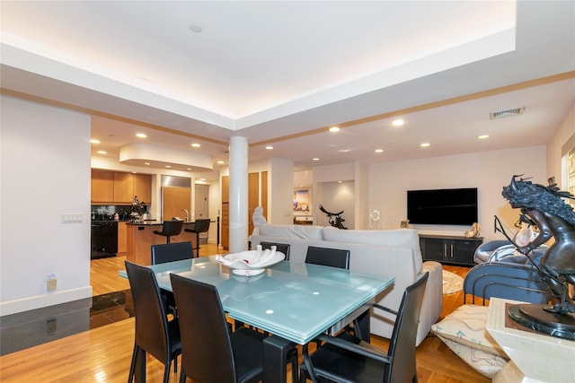 1 Portico Ct Unit 200, Great Neck, NY 11021 - dining space featuring recessed lighting, wood finished floors, ornate columns, and a raised ceiling