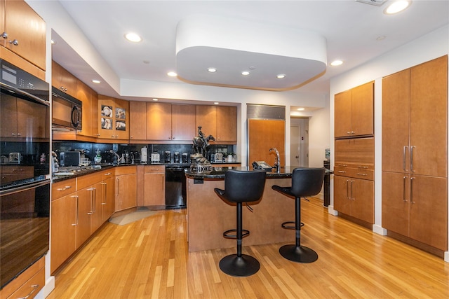 1 Portico Ct Unit 200, Great Neck, NY 11021 - kitchen featuring black appliances, brown cabinets, light wood-type flooring, and recessed lighting
