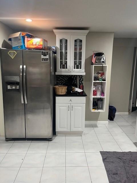 226 14th Ave, West Babylon, NY 11704 - kitchen featuring stainless steel fridge with ice dispenser, glass insert cabinets, dark countertops, and white cabinets