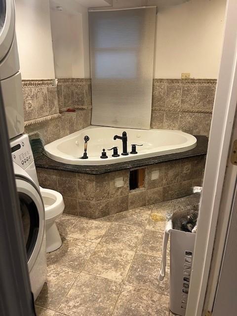 226 14th Ave, West Babylon, NY 11704 - full bathroom with stacked washer and clothes dryer and a garden tub