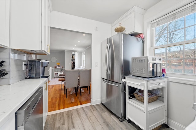 64-41 Springfield Blvd Unit B, Bayside, NY 11364 - kitchen with stainless steel appliances, white cabinetry, light wood-type flooring, decorative backsplash, and light stone countertops