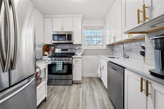 64-41 Springfield Blvd Unit B, Bayside, NY 11364 - kitchen with appliances with stainless steel finishes, light wood-style floors, white cabinetry, and decorative backsplash