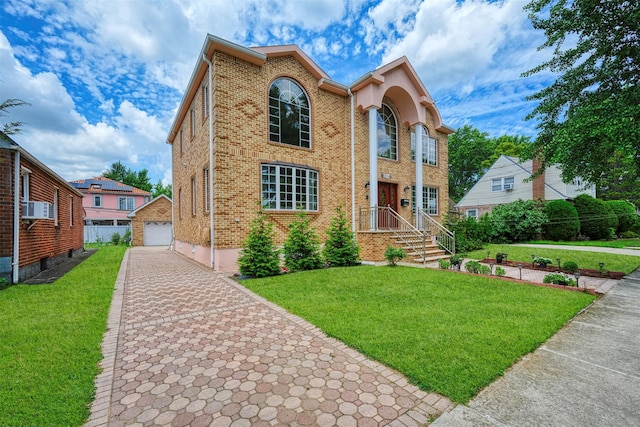 83-14 266th St, Glen Oaks, NY 11004 - view of front facade with brick siding, a garage, an outbuilding, and a front lawn