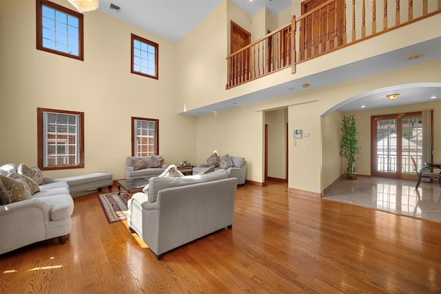83-14 266th St, Glen Oaks, NY 11004 - living area featuring arched walkways, healthy amount of natural light, wood finished floors, and a towering ceiling