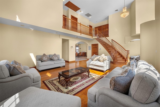 83-14 266th St, Glen Oaks, NY 11004 - living area with arched walkways, stairway, a high ceiling, and wood finished floors