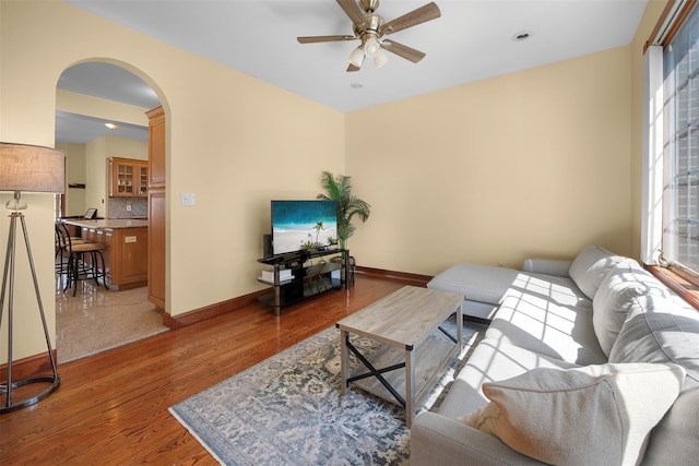 83-14 266th St, Glen Oaks, NY 11004 - living room featuring a ceiling fan, arched walkways, and light wood-type flooring