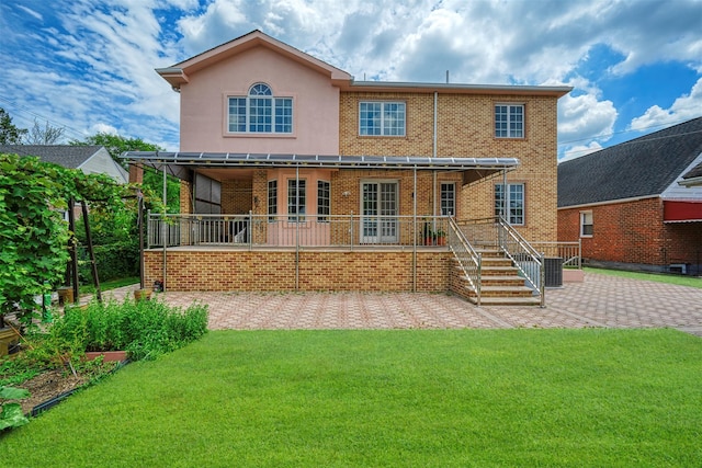 83-14 266th St, Glen Oaks, NY 11004 - rear view of property with a patio area, a lawn, and brick siding